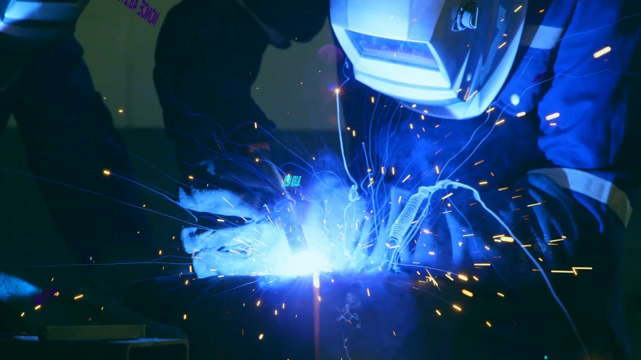Welder striking torch, arc welding joint, sparks flying under neon overlay for designers creators