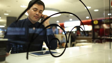hombre de negocios con pad en el café hablando por teléfono