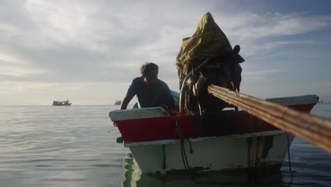 a man in a small boat on the water under a cloudy sky