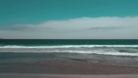 aerial moving towards the waves at the beach