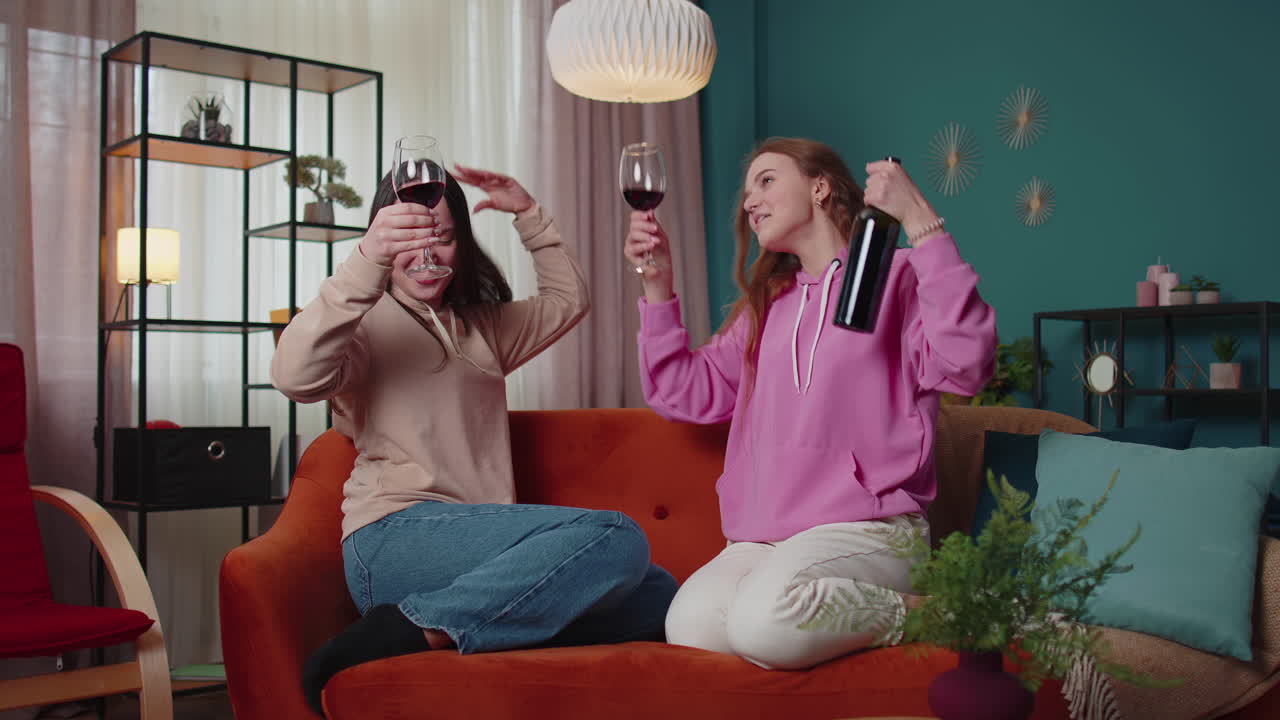 여자 친구 형제 자매 와인 컵을 걱거리며 환호하고, 술을 마시며, 생일을 축하하는 집 파티