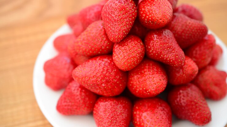 Strawberry on a wood background. Shooting in the movement