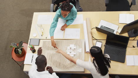 Happy-diverse-architects-looking-at-architectural-models-at-office