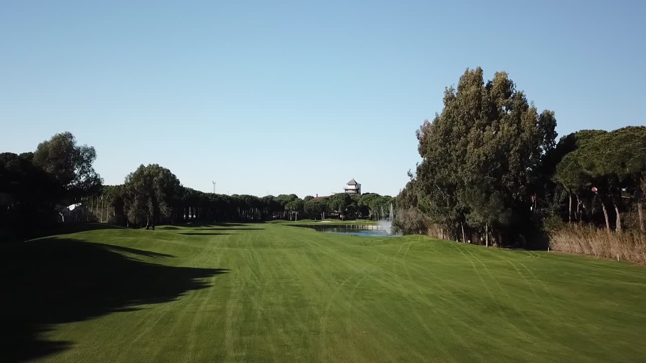 낮은 앵글 샷으로 생생한 골프장 위로 천천히 날아가는 드론