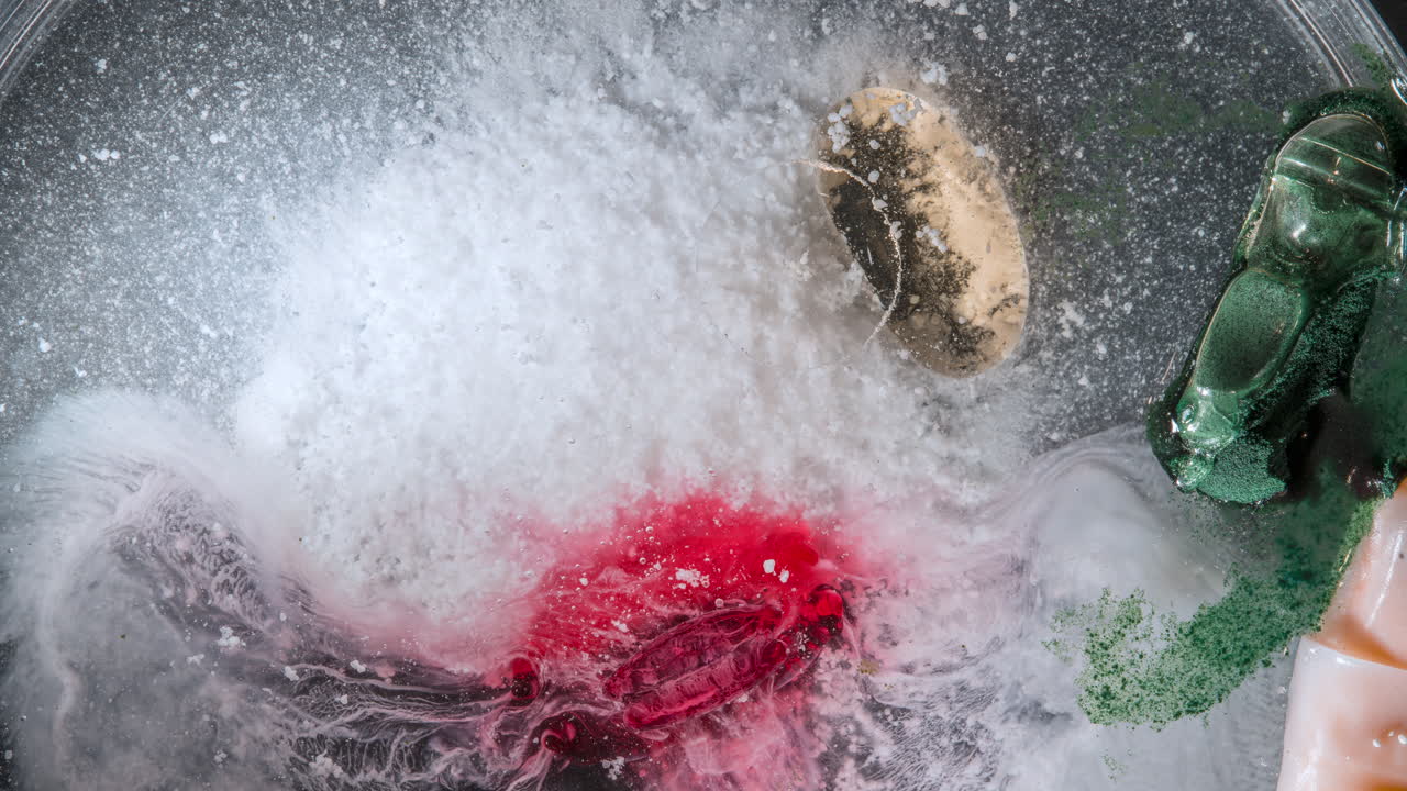Pills dissolving in liquid, with colorful powders mixing, timelapse footage