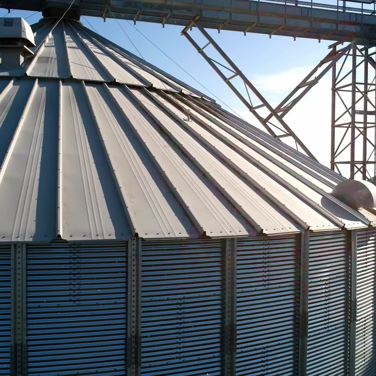 Large storage tanks in nature. Grain terminals. Industrial metal bins for agribusiness. Modern warehouse. Close-up. Aerial view.
