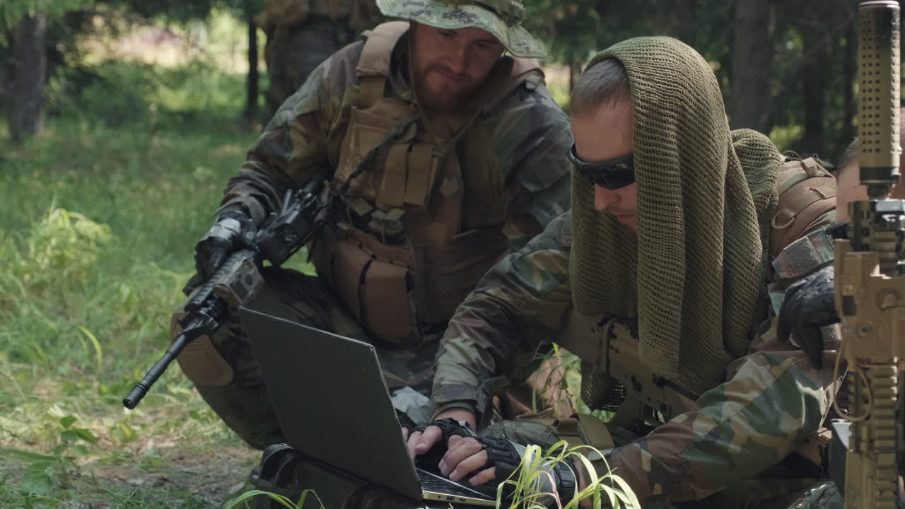 Military Men Using Laptop In Jungle