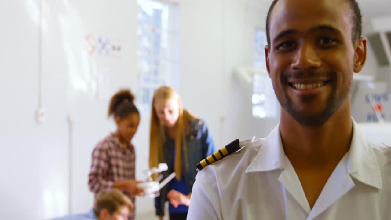 Male pilot standing with arms crossed while kids using drone 4k