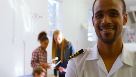 male pilot standing with arms crossed while kids using drone 4k
