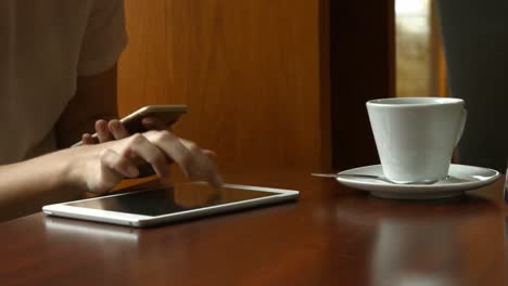 mujer de negocios que usa teléfonos inteligentes y tabletas