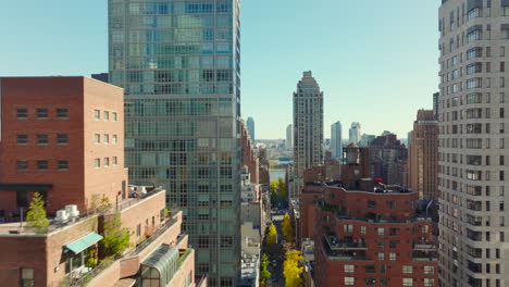 Forwards-fly-above-high-rise-buildings-in-residential-district.-Autumn-colour-foliage-on-trees.-Manhattan,-New-York-City,-USA