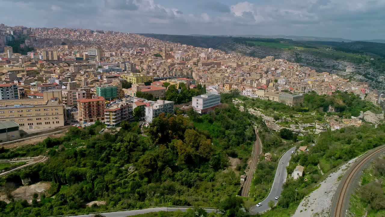 tomada aérea de un paisaje urbano con un telón de fondo montañoso en panoramica su ragusa e su ibla en italia