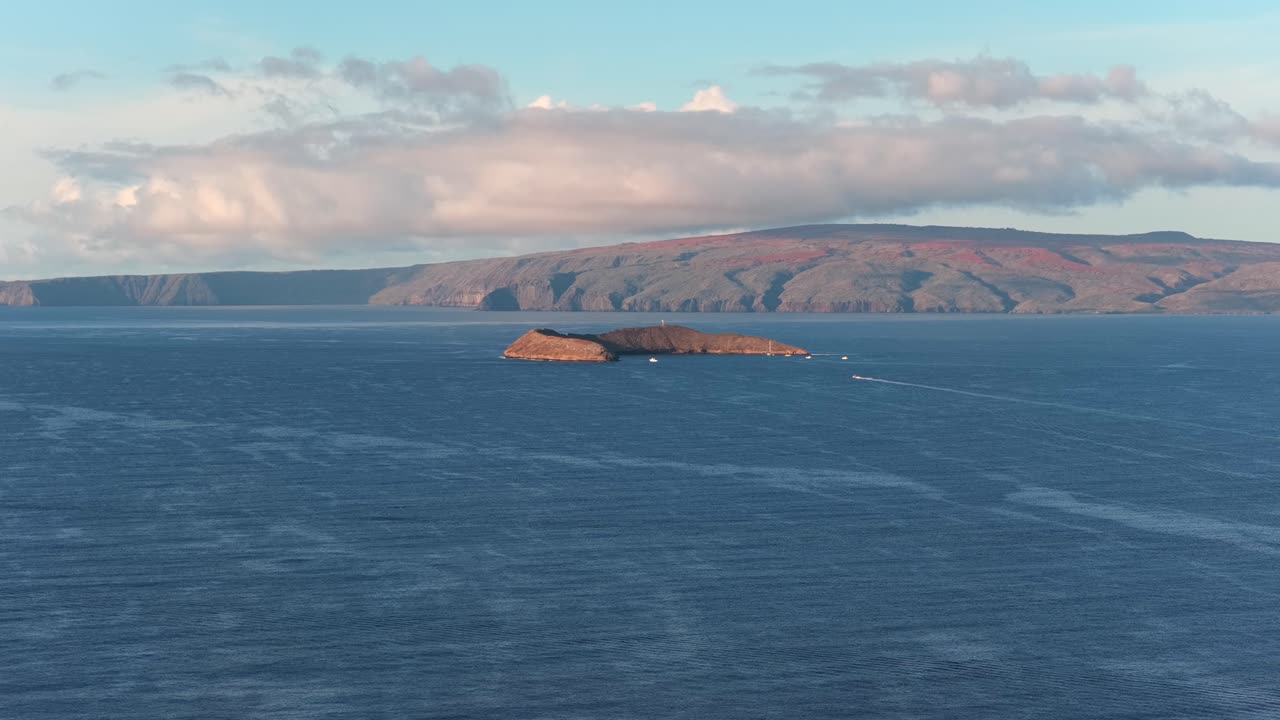 Smooth drone ascent over the Pacific, revealing Molokini Crater against the Maui coastline. A cinematic rise-and-tilt shot ideal for travel, tourism, nature documentaries, and coastal storytelling