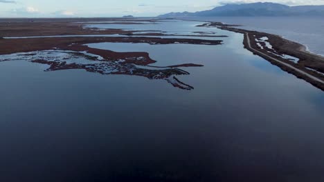 Top-down-and-reveal-aerial-shot-of-protected-natura-lagoons-next-to-the-sea-in-winter,-Greece