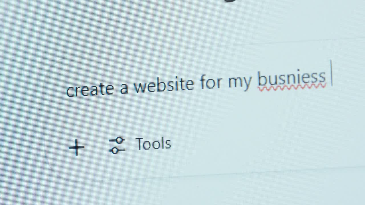 A user types “create a website for my busniess” into an AI chatbot, showing a spelling mistake—highlighting growing dependence on AI and declining attention to detail