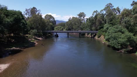 fly through of pristine river with fishermen and people splashing and playing