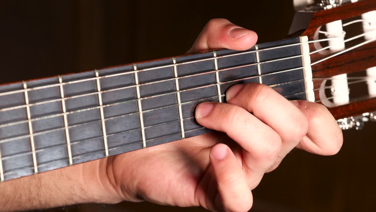 guitarrista izquierdo presionando cuerdas para acordes, primer plano