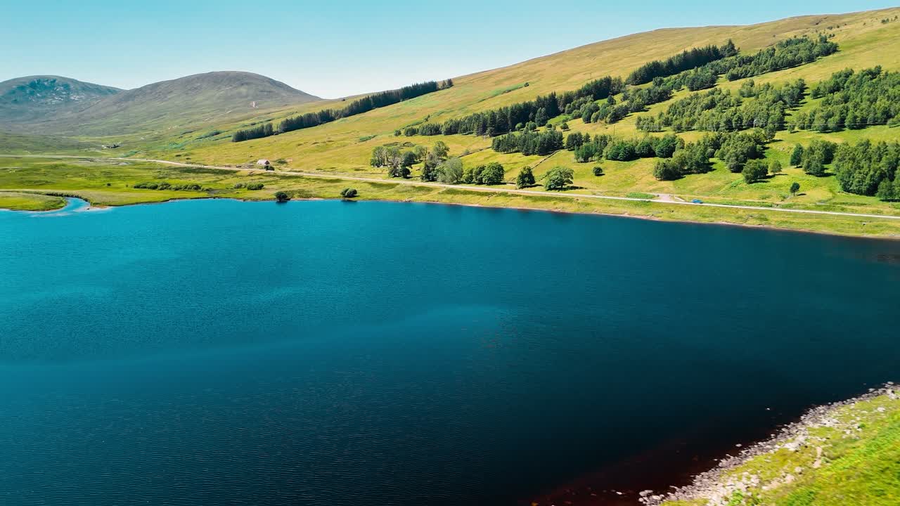 Scenic Lake Surrounded by Mountains and Green Landscape