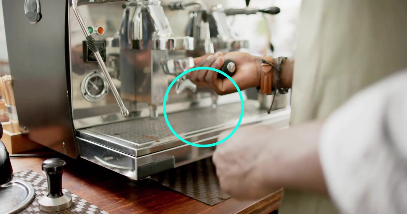 Barista che afferra il pressino, poi pressa il portafiltro per un espresso, mentre un indicatore animato sale.