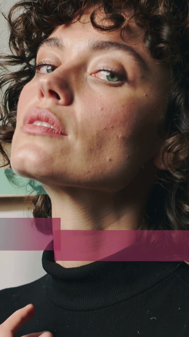Vertical video: Adjusting woman's hand pulling black turtleneck collar in studio with color bars
