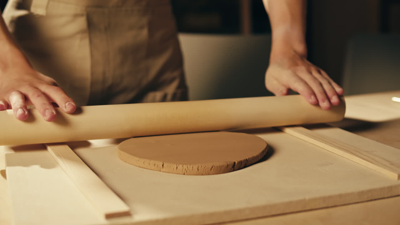 donna che modella l'argilla con un rotolo