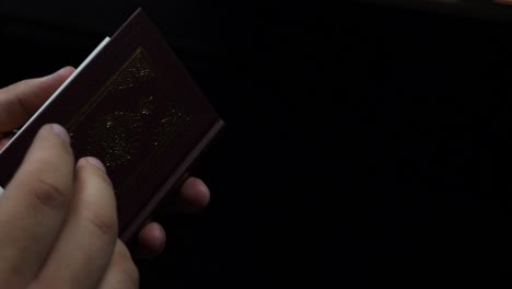 una persona abre el noble corán desde su comienzo y hojas a través de él