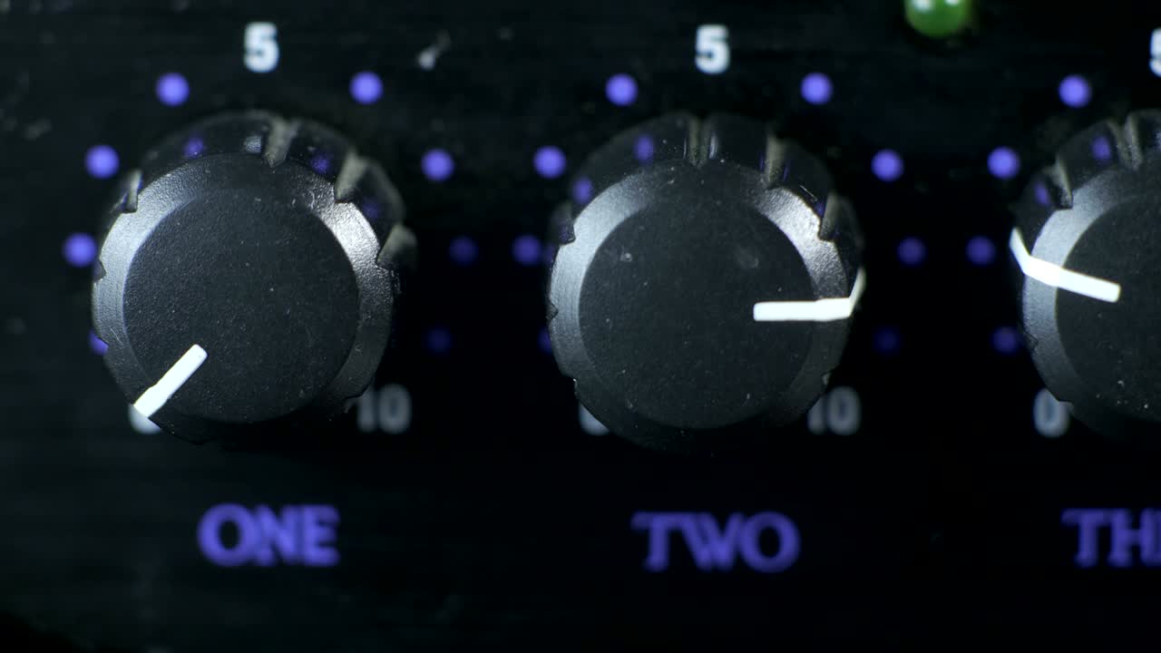 dedos masculinos girando el botón del amplificador de auriculares