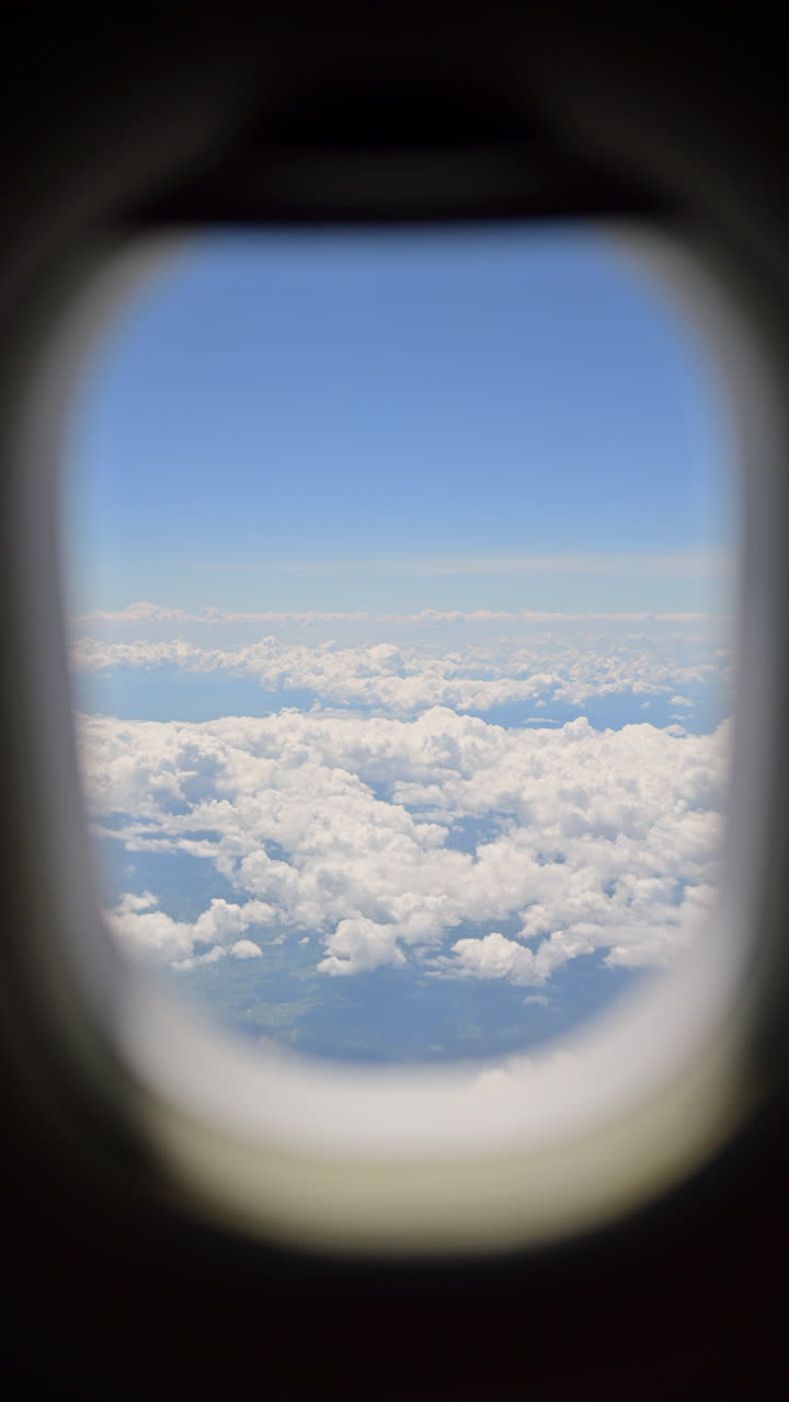 View of the clouds from an airplane window. Vertical