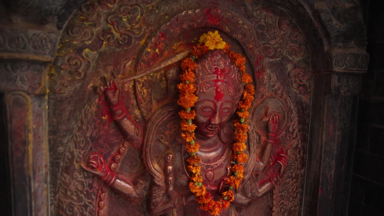 pintura roja y naranja en una estatua de dios del templo en katmandú, nepal en la base de los himalayas