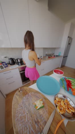 young woman preparing fresh spring rolls in a kitchen