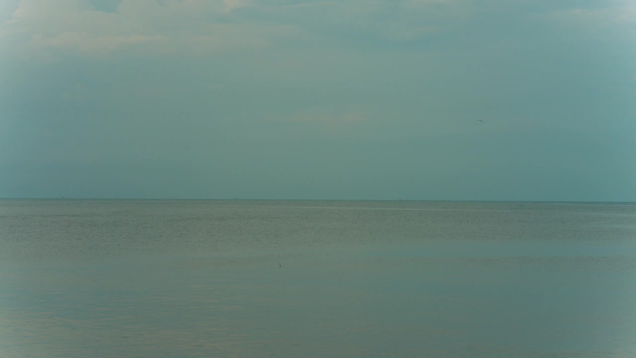 Minimalist view of open ocean water under overcast sky background