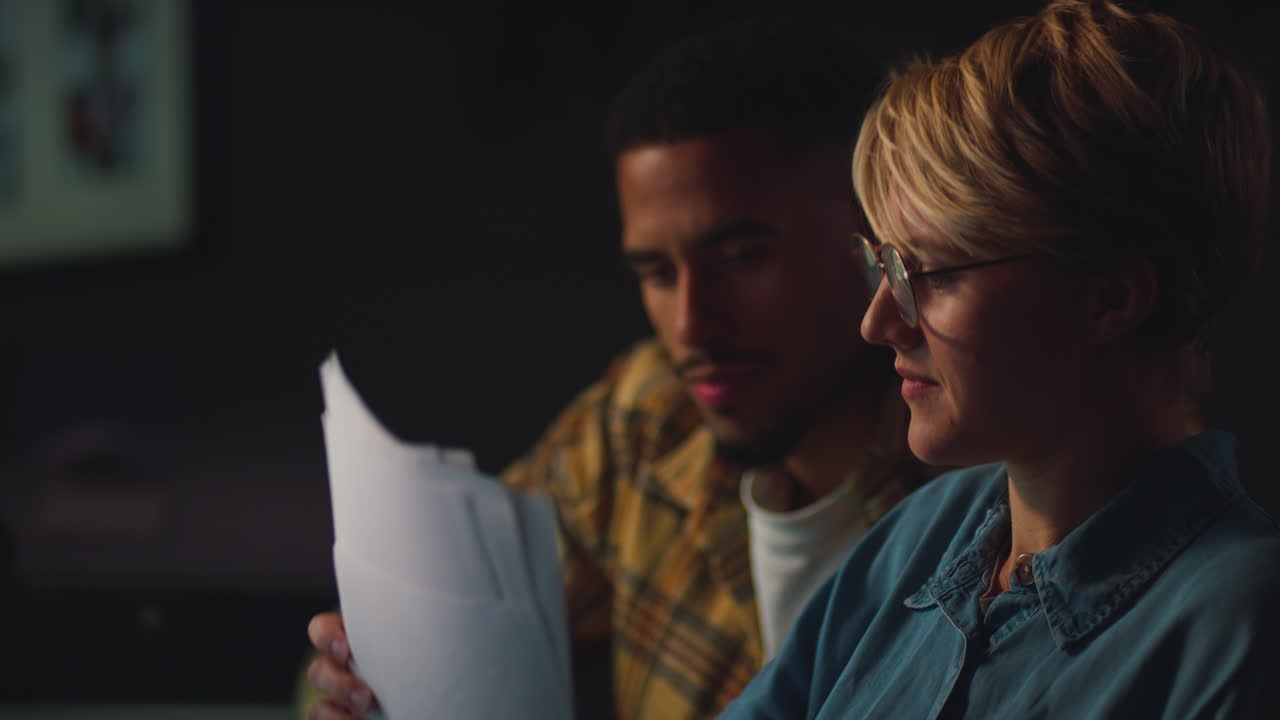 cerca de dos colegas de negocios en escritorios en la oficina trabajando hasta tarde en un proyecto de computadora juntos