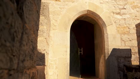 Portugal-Loule-stone-wall-reveal-castle-door-in-truck-camera-movement-at-sunshine-4K