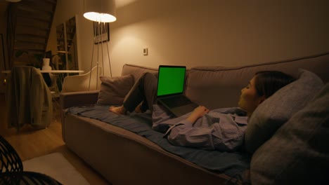 mujer relajándose en el sofá con una computadora portátil