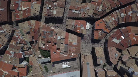 Aerial-looks-onto-tourist-crowd-in-Pamplona,-running-with-the-bulls