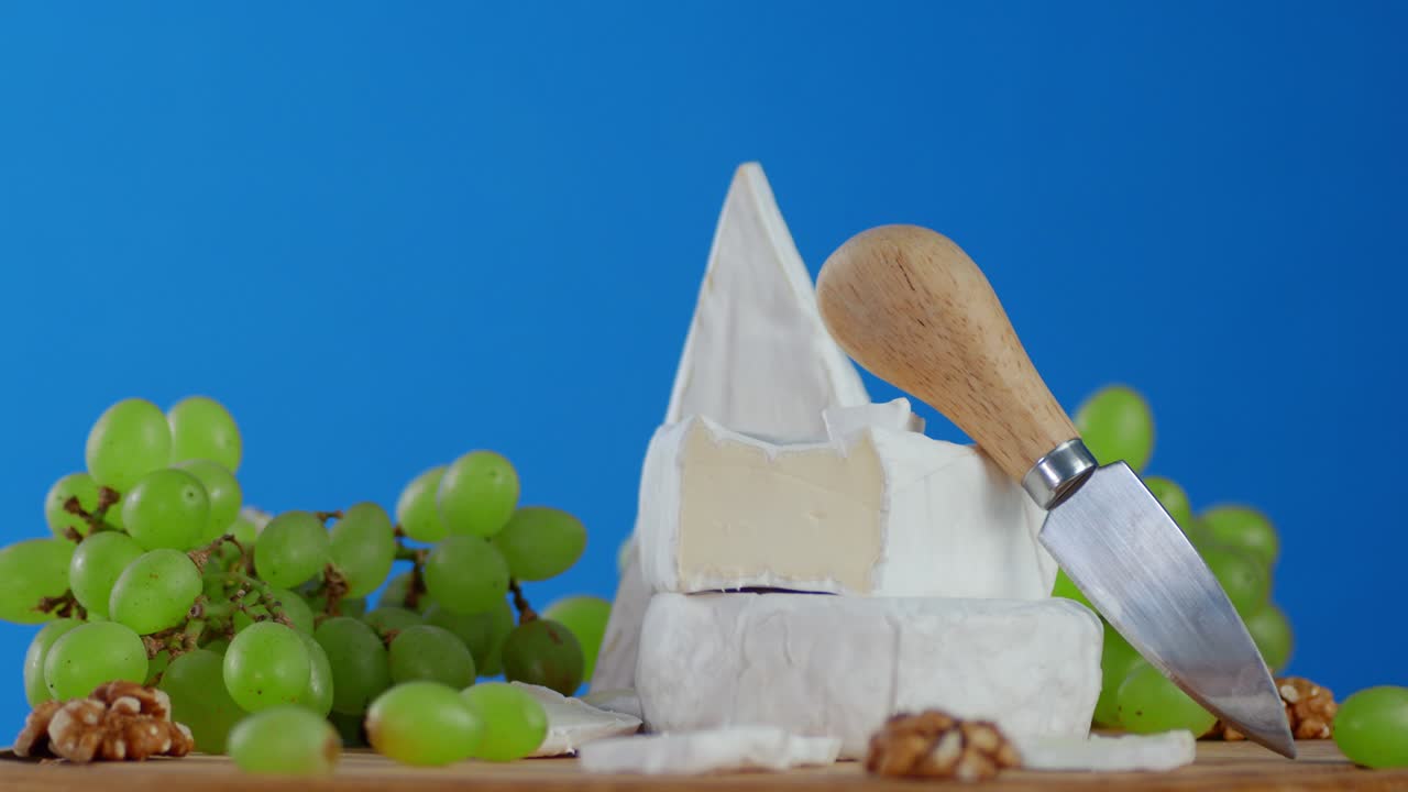 포도와 walnuts와 camembert 치즈는 천천히 회전합니다.