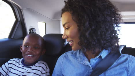 Una-Joven-Madre-Negra-Con-Un-Niño-En-Un-Coche-Yendo-De-Viaje-Por-Carretera