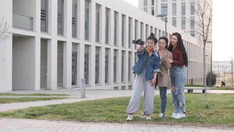 asian female friends bloggers creating content for social media while making a video with a camera.