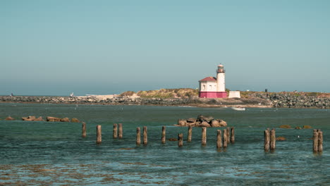 Malerischer-Blick-Auf-Den-Coquille-River-Lighthouse-In-Der-Nähe-Von-Bandon,-Oregon-Mit-Einem-Im-Wasser-Segelnden-Boot---Zeitraffer,-Totale