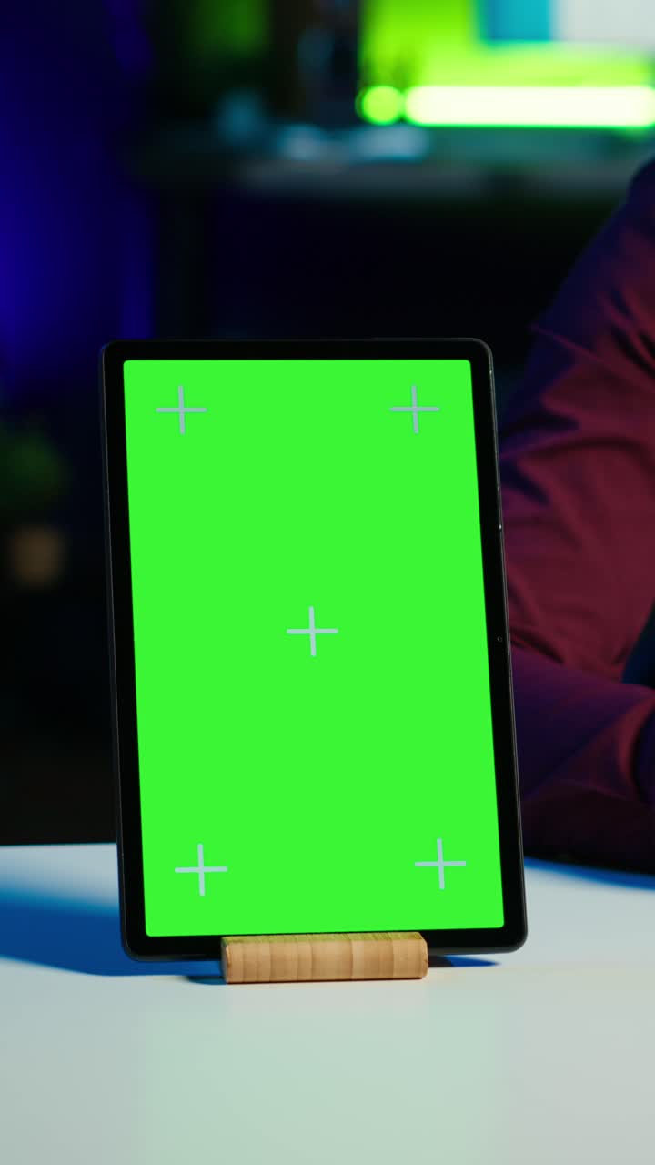 Vertical video Happy influencer in studio filming chroma key tablet review