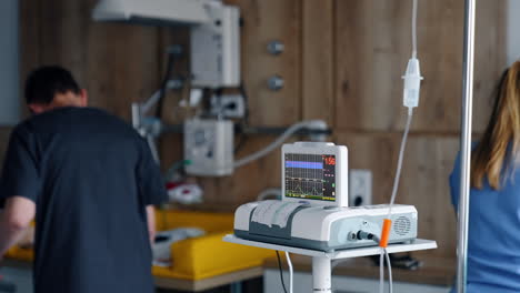 cardiotocography equipment working in the delivery room. medics preparing for labour at backdrop in blur.