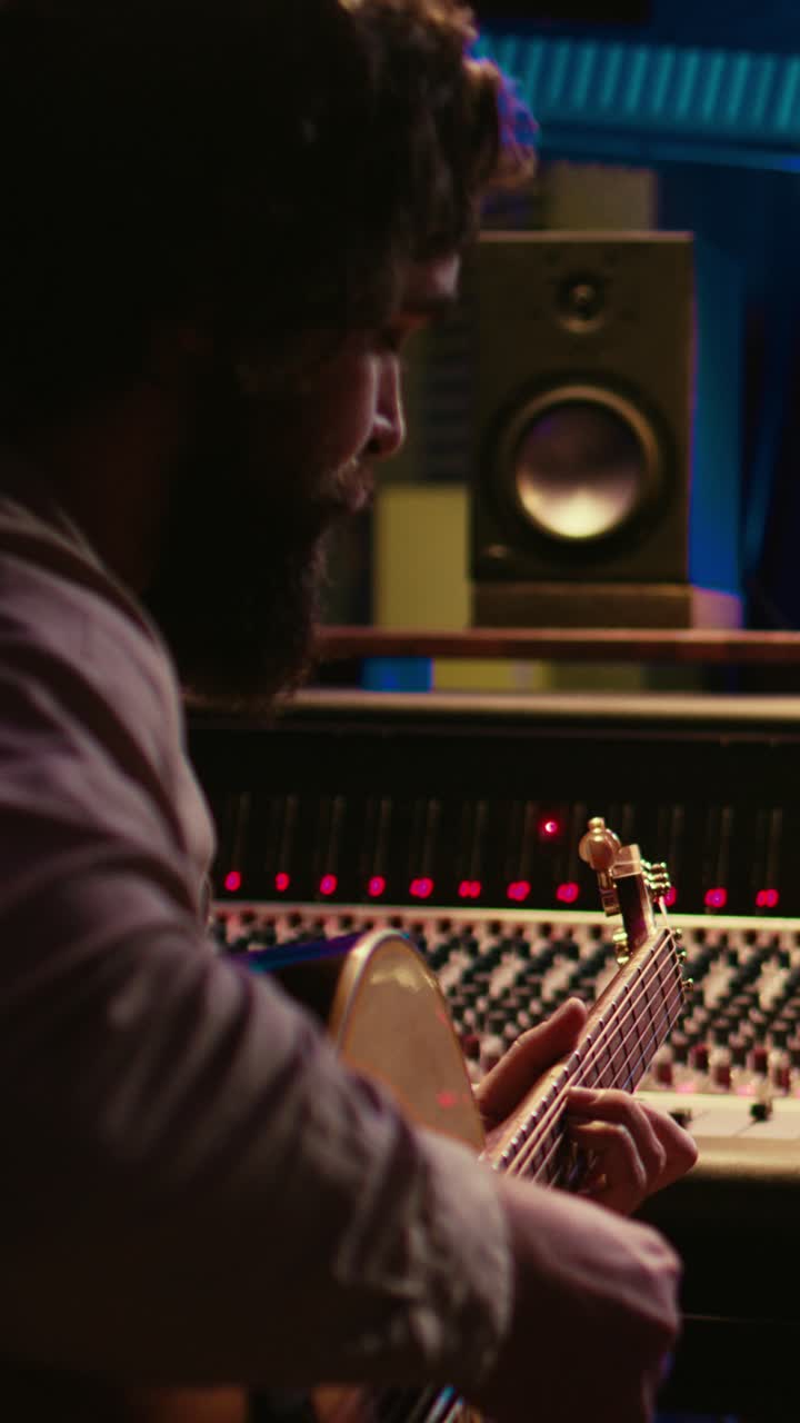 Man Playing Acoustic Guitar in a Professional Music Recording Studio