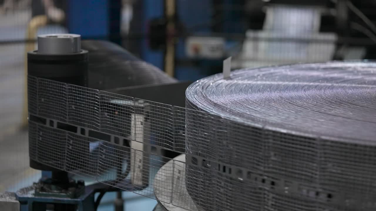 Automatic line for stamping lead strip. In the future, the tape will be used for the production of accumulator batteries