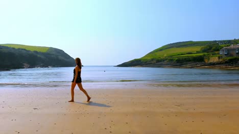 Woman-walking-on-the-beach-on-a-breezy-day-4k