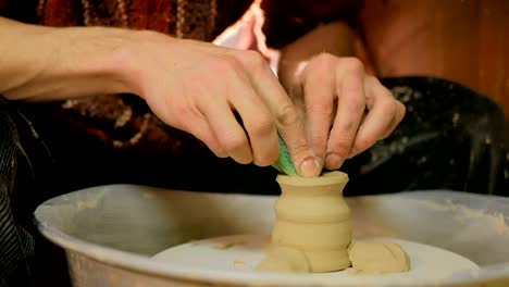 professional potter shaping mug with special tool in pottery workshop