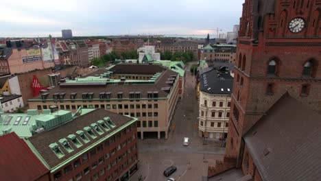 flying over city church in malmö, sweden. aerial shot of cityscape and church tower