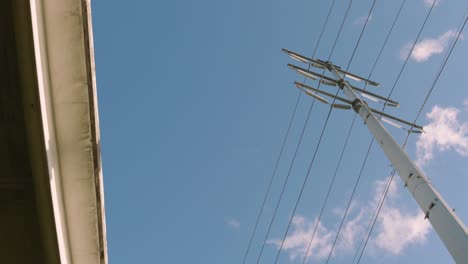 Niedrige-Winkelansicht-Eines-Strommastes,-Während-Wolken-über-Uns-Hinwegziehen