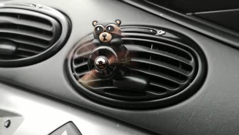 Teddy-bear-racing-aircraft-with-fast-spinning-propeller-on-car-interior-air-conditioner-dashboard-vent