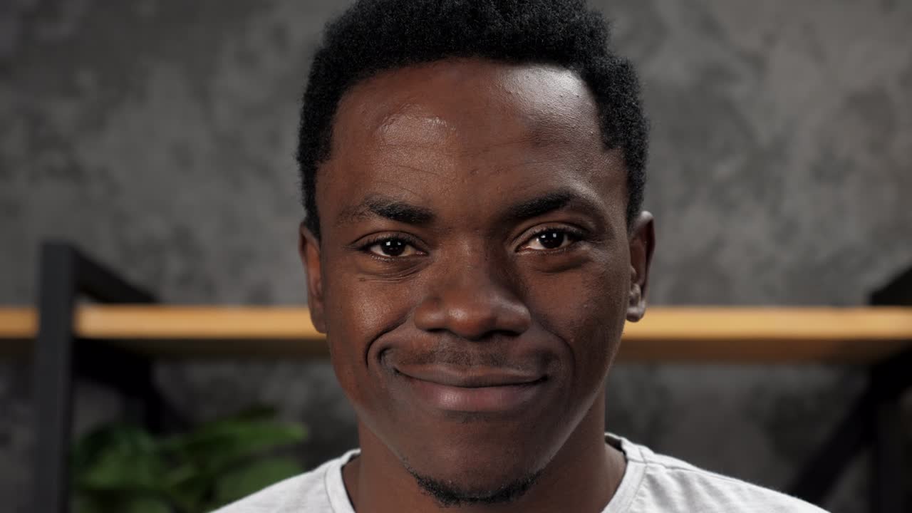 rostro sonriente de cerca hombre afroamericano mirando a la cámara, de pie en la oficina