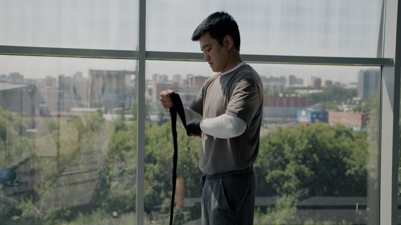 Man Wrapping Boxing Wraps Before Training